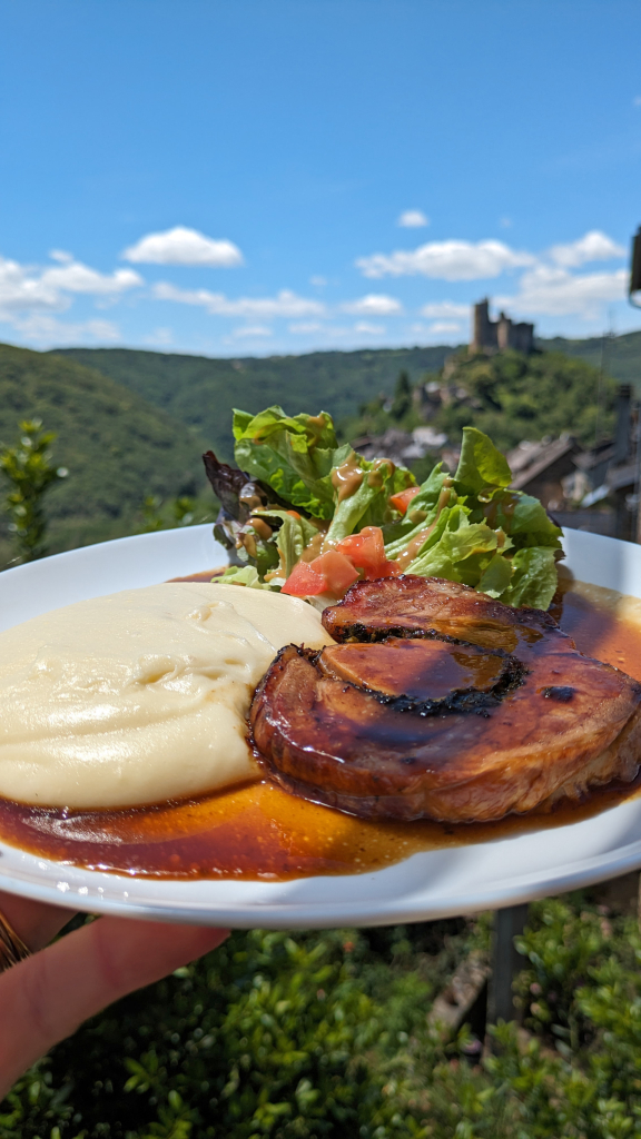 Assiette d'Astet et aligot avec le château de Najac en fond