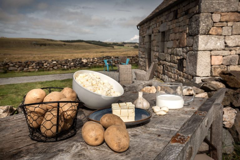 Ingrédients pour la préparation de la recette de l'aligot devant un buron