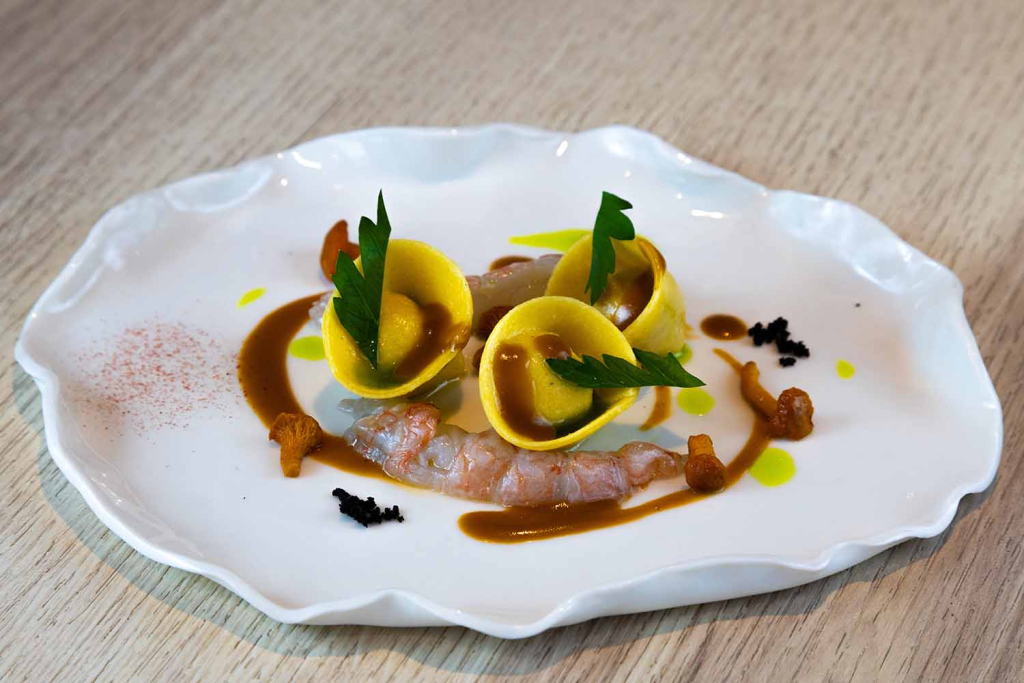 Ravioli à la farce fine de volaille, sauce cardinal, langoustine et girolles