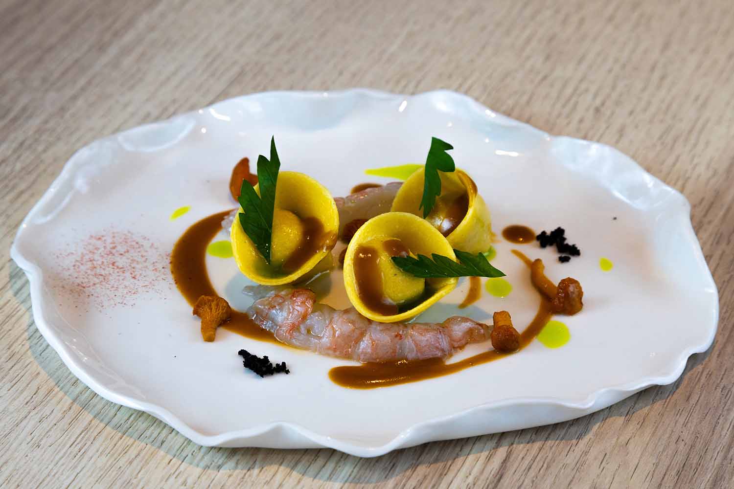 Ravioli à la farce fine de volaille, sauce cardinal, langoustines et girolles