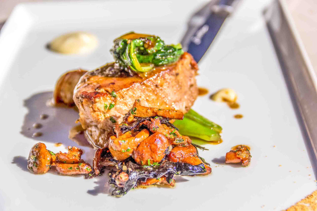 Pièce de veau du Ségala cuisinée servie sur une assiette avec des petits légumes Pièce de veau du Ségala cuisinée servie sur une assiette avec des petits légumes
